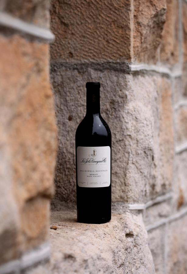 Single bottle of red wine against a stone background.